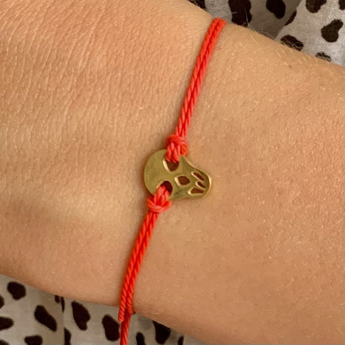 Bracelet Calavera Rouge porté au poignet, tête de mort dorée sur cordon rouge - MY KNOT PARIS